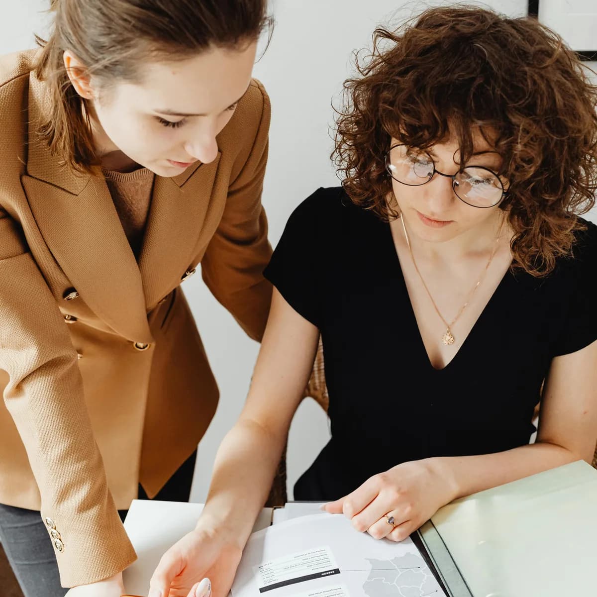 Two professionals collaborating over a document, the embedded-team feel of working with Finacco
